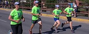 Photograph of several Missoula Marathon Runners crossing the finish line as part of the Run 4 Kids fundraising team.