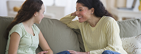 Mother and daughter on couch talking