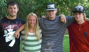 Group of teens smiling at camera arm in arm
