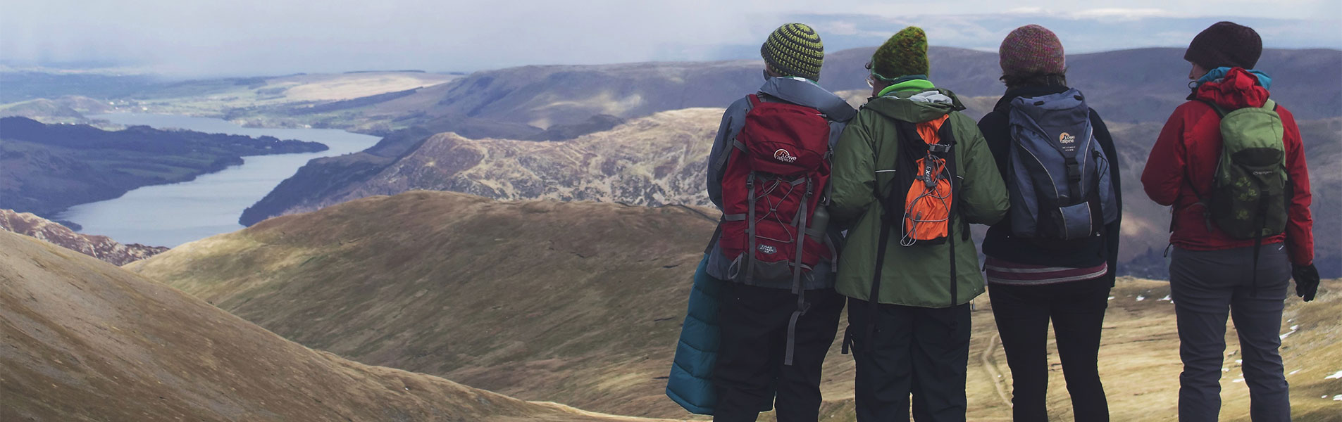 Youth Homes - four young adults look over a vast river and hill scape