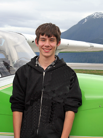 Young adult standing in front of a small plane