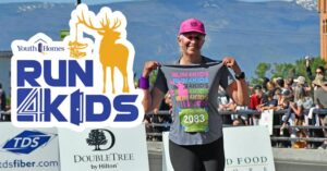 Run 4 Kids - runner holding up t-shirt