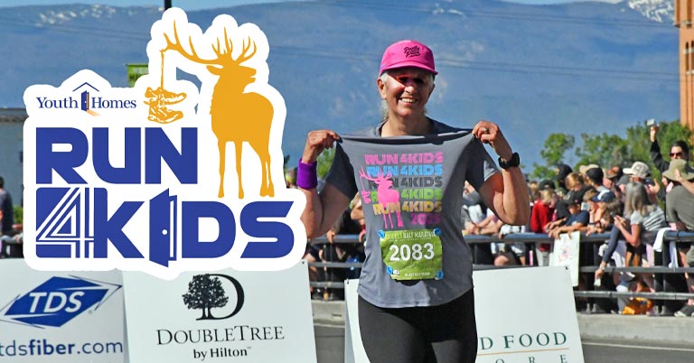 Run 4 Kids - runner holding up t-shirt