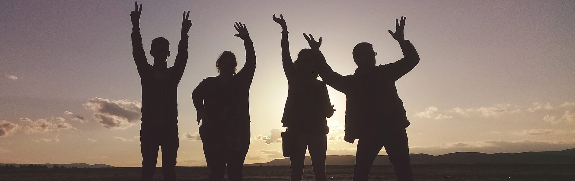 4 silhouettes against a sunset