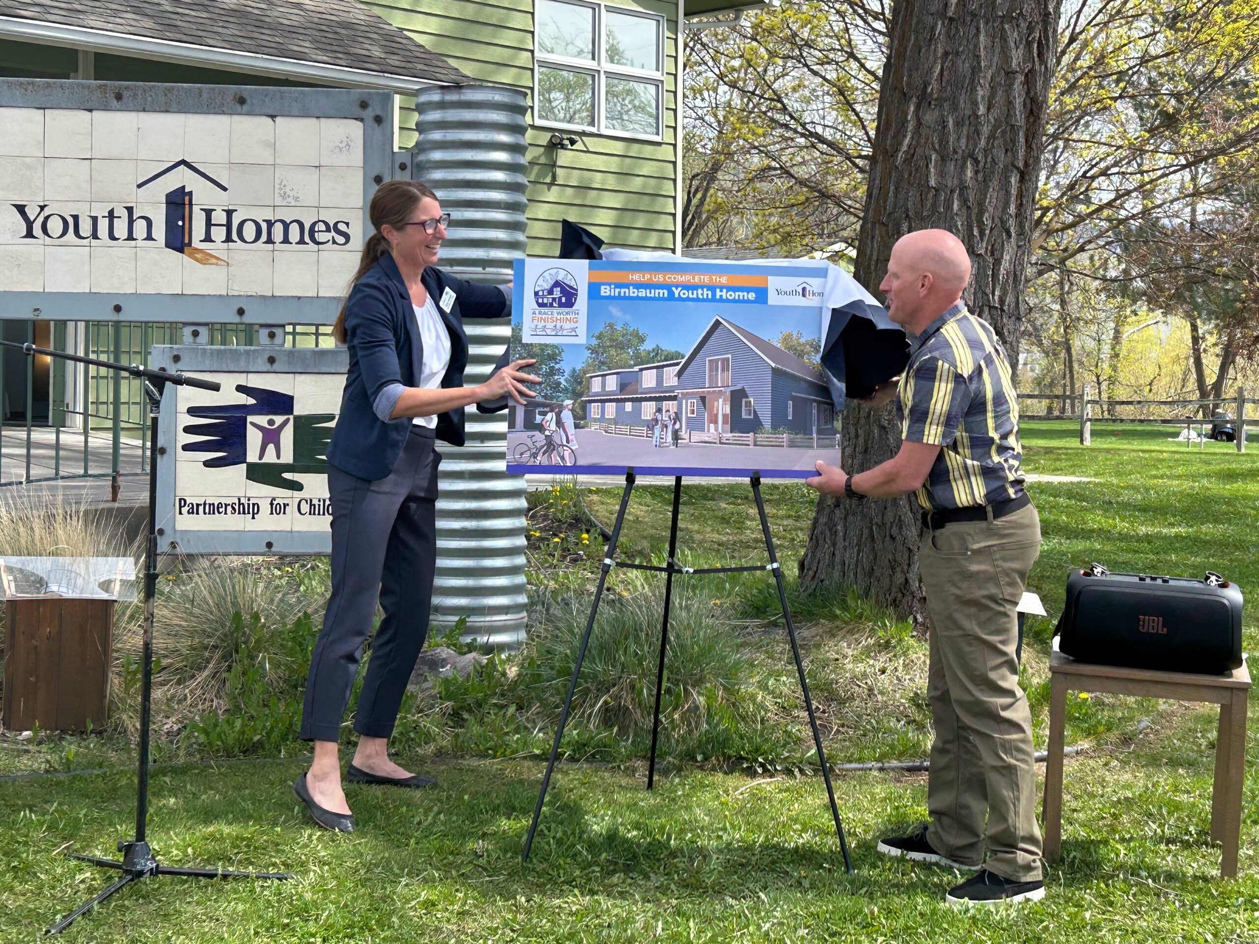 Youth Homes CEO Amy Schaer, left, and Mike Birnbaum unveil the design for a new youth crisis shelter during a campaign launch event Monday. Credit: Katie Fairbanks/MTFP