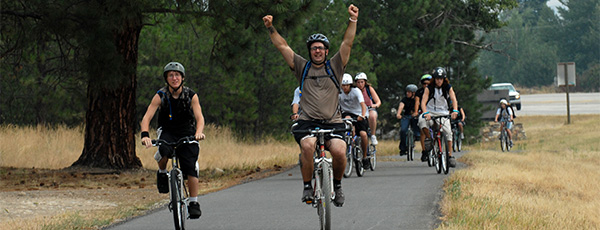 Bike riders arms up in the air with smiles