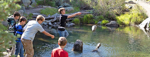 Kids fishing by a small pond